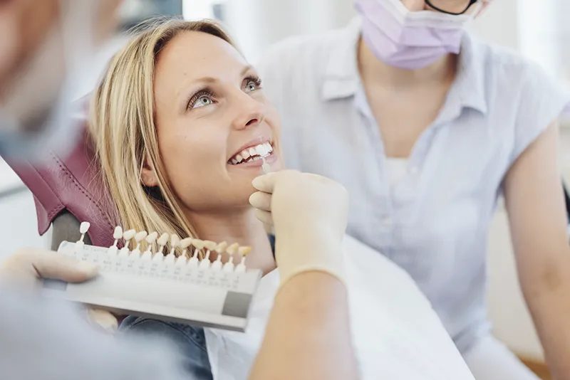 Zahnarzt vergleicht Weißgrade von Zahn und Modell