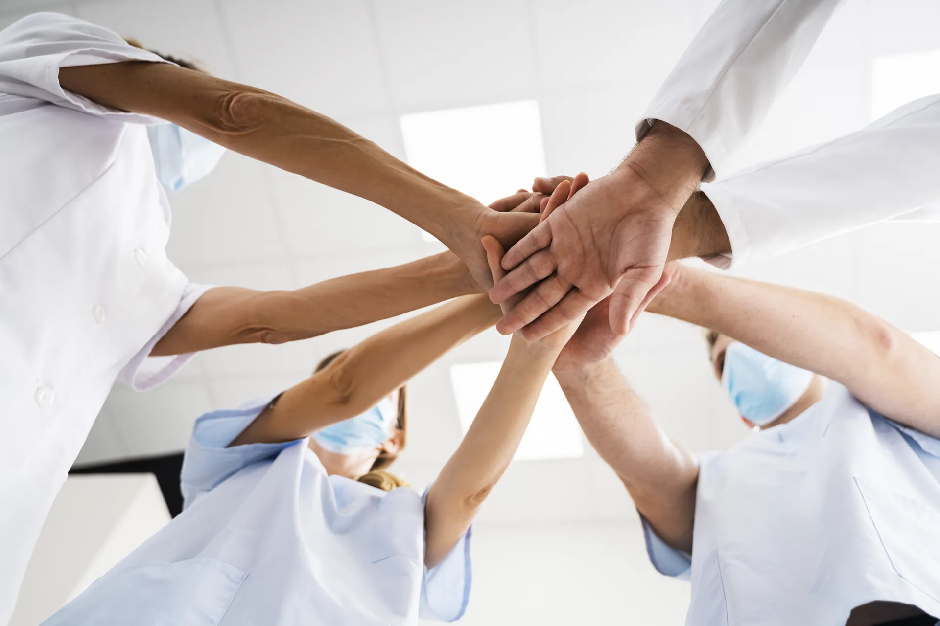 Hände von zahnmedizinischem Personal treffen sich in der Mitte