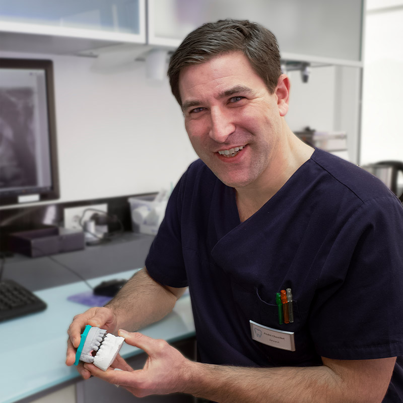 Dr. André Chenillet mit Modell eines Kiefers in der Hand